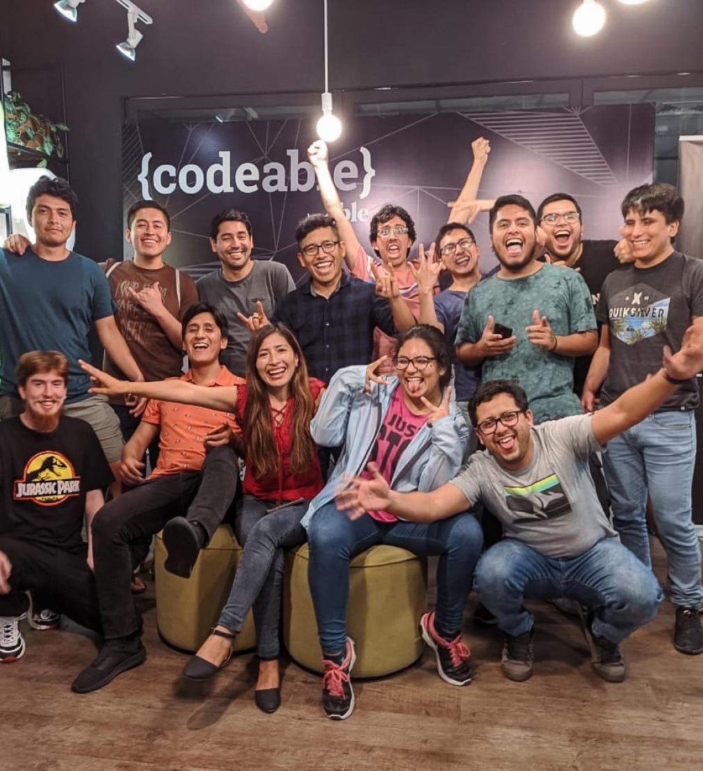 Team photo of 12 young men and 2 young women who are part of the Codeable cohort in the Codeable office.